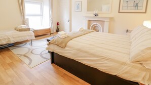 Una habitación de hotel con dos camas, una chimenea, un espejo grande y un cuadro en la pared.