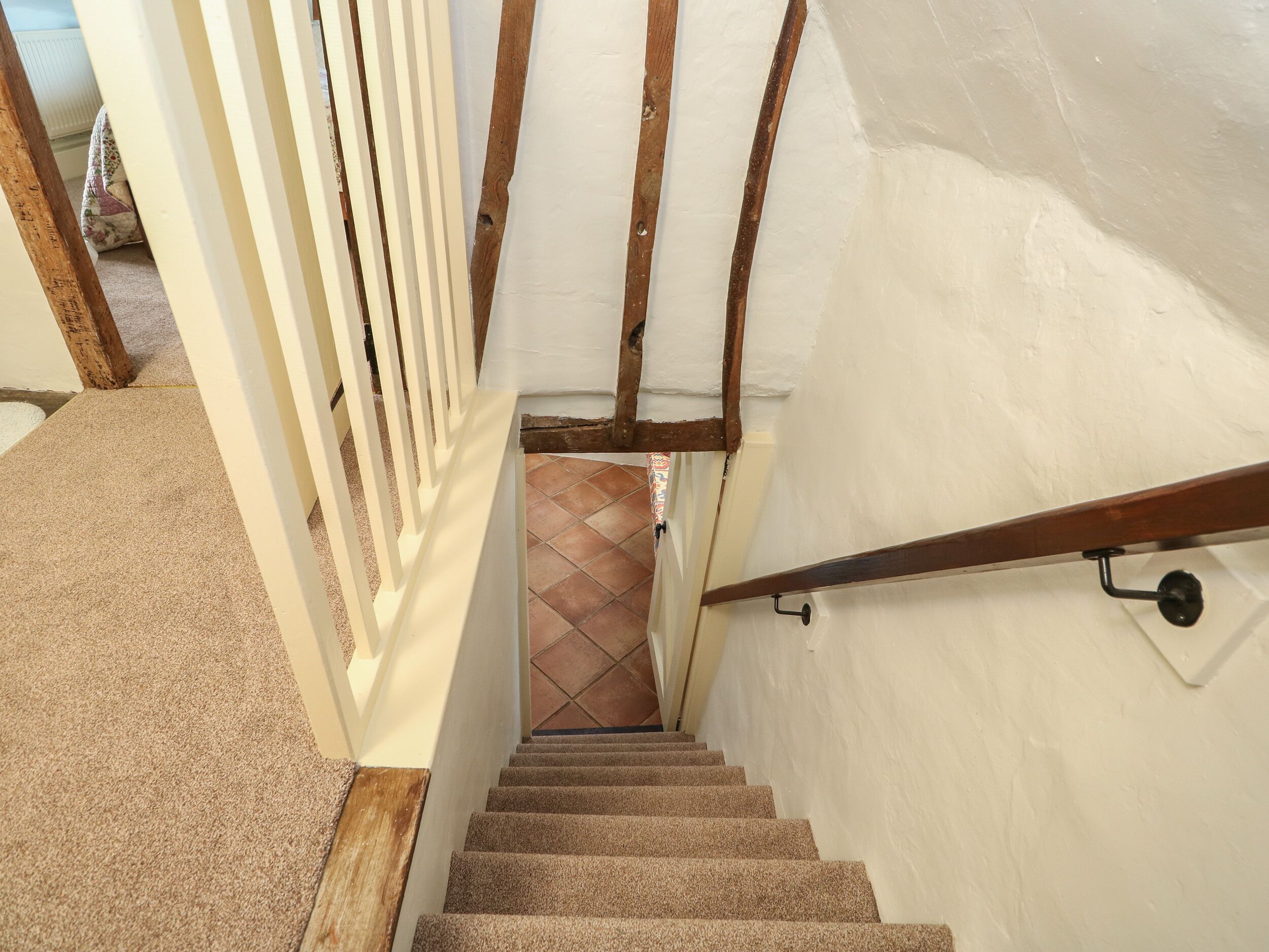 A staircase with wooden handrails and a carpeted floor.
