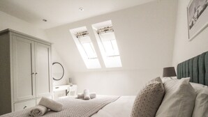 A bedroom with a bed, a desk, a chair, and a wardrobe. - Meadow View Barn (Wareham)