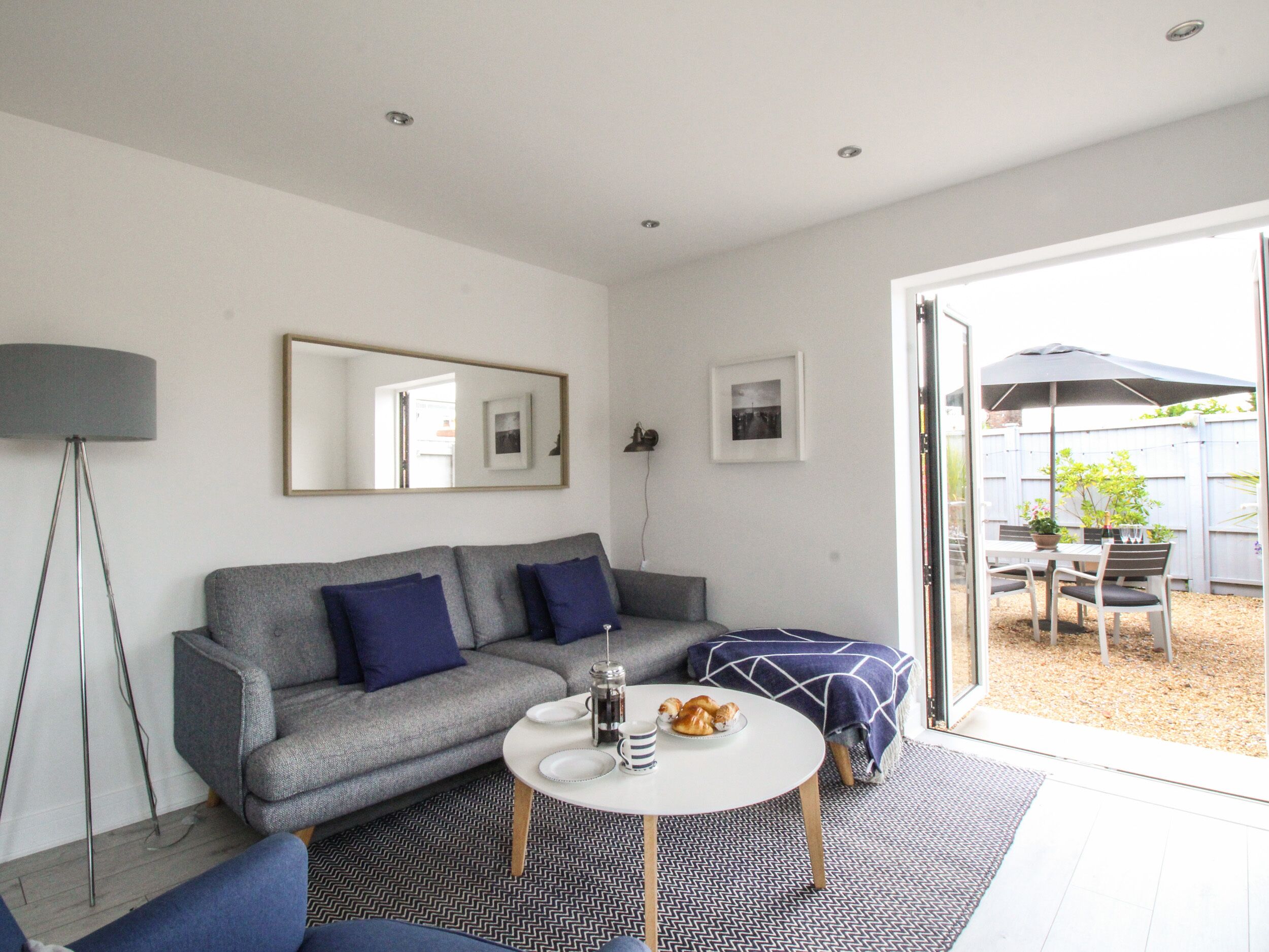 A modern living room with a grey sofa, a coffee table, and a floor lamp.