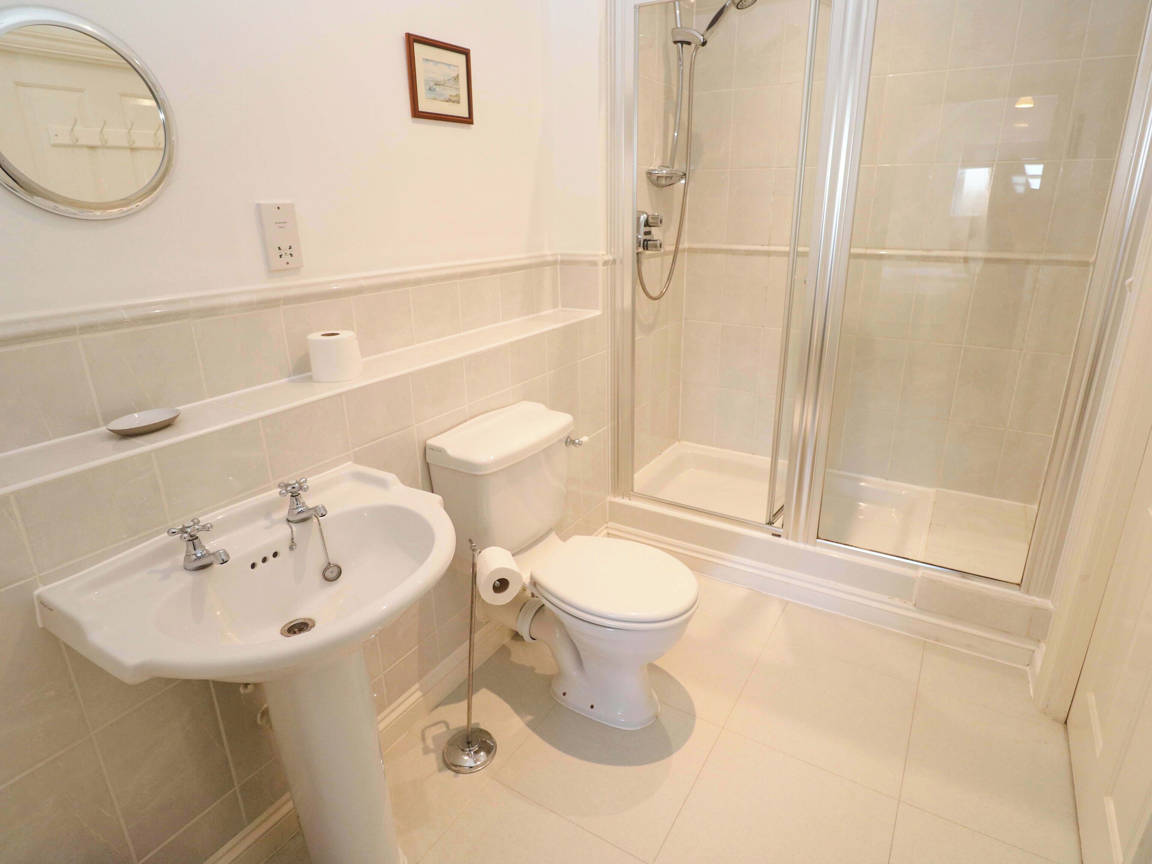 A bathroom with a sink, toilet, and glass-enclosed shower.