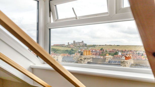 A view from a window overlooking a historic building and a residential area. - Salty Fox (Whitby)