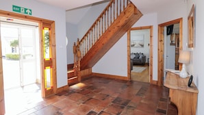 A spacious lobby with a wooden staircase, tiled flooring, and a reception desk. - Seashells (Coleraine)