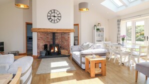 Un salon moderne avec une cheminée en briques, une grande horloge et une lucarne.