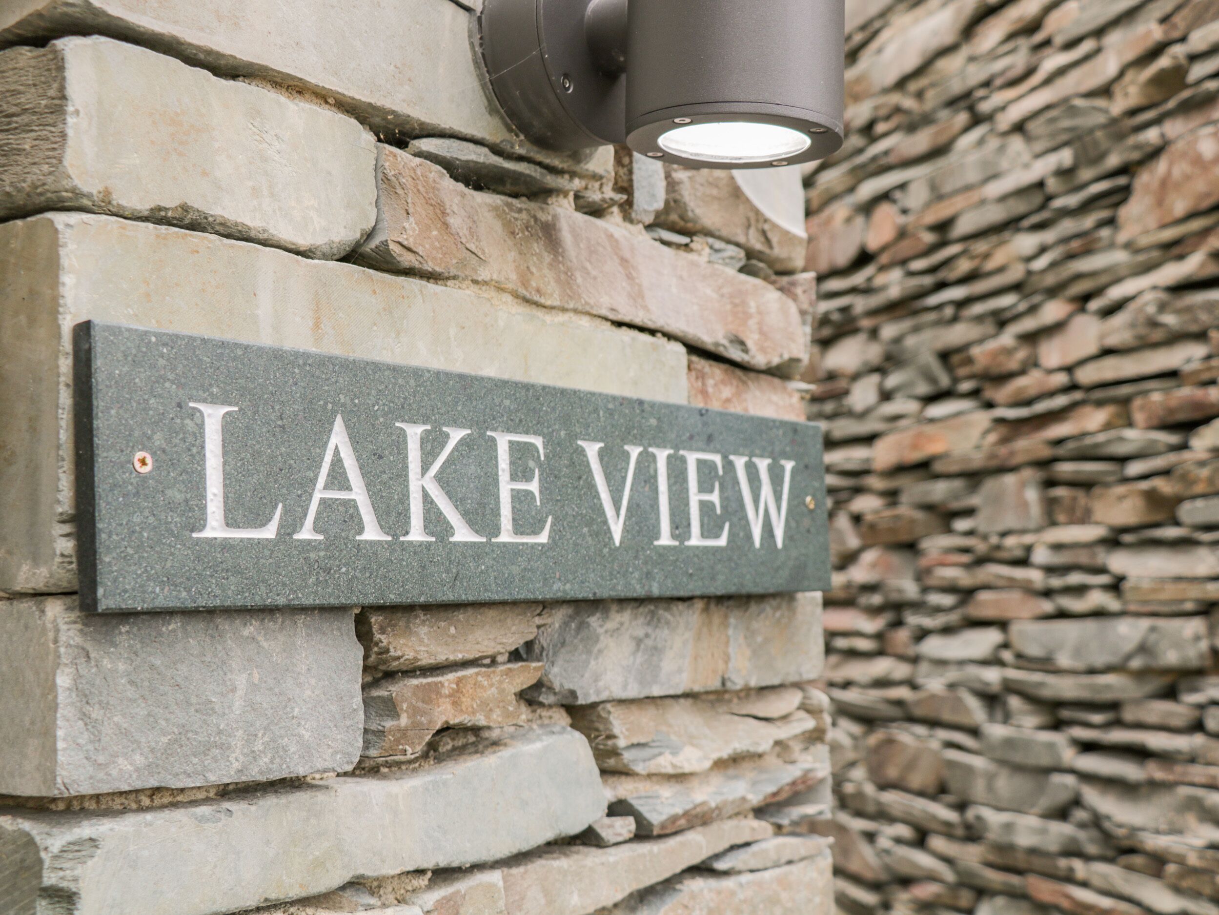 A stone wall with a sign that reads "LAKE VIEW".