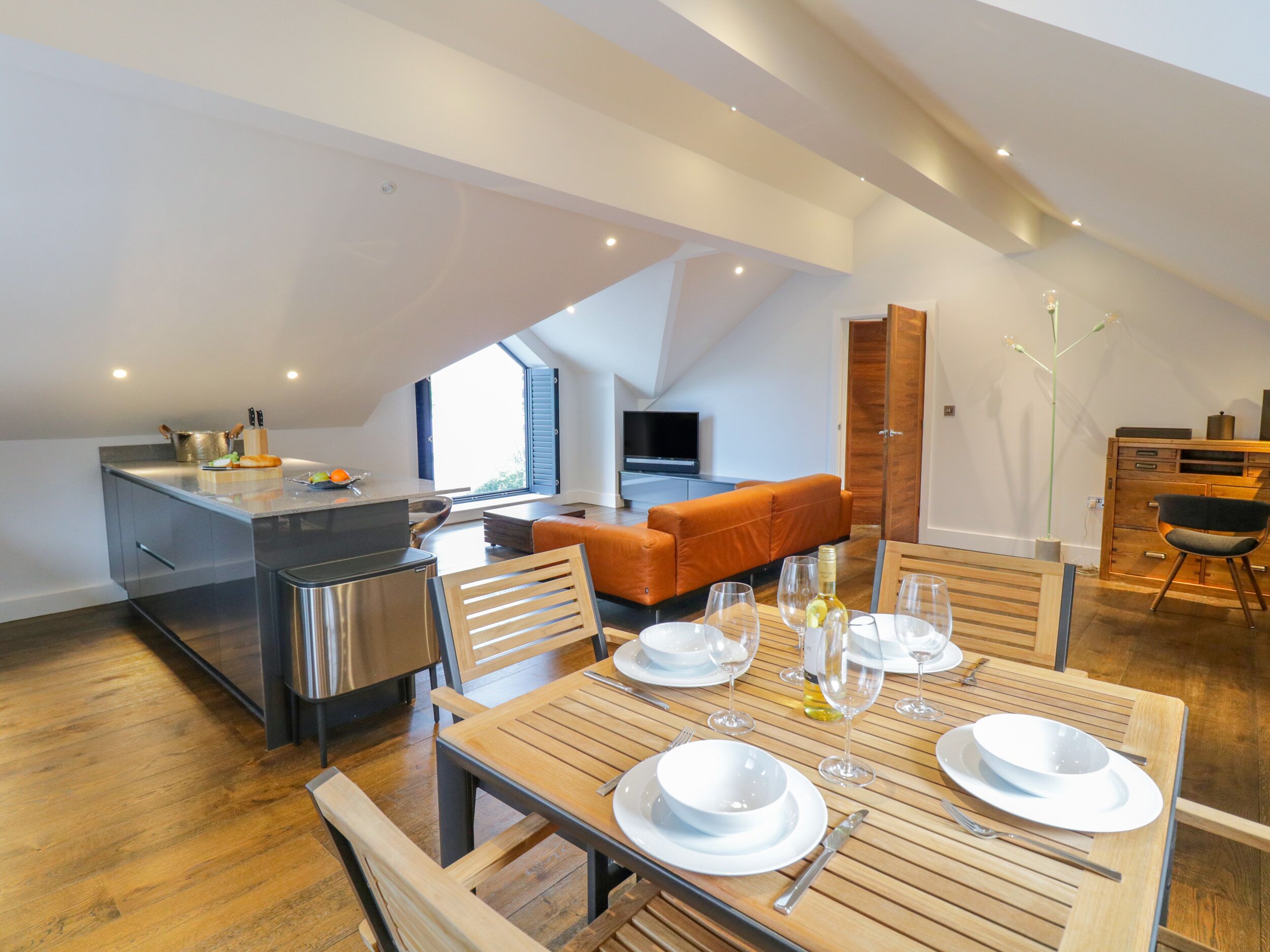 A modern loft apartment with a kitchen, dining area, and living space.