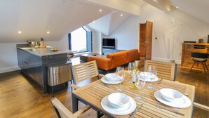A modern loft apartment with a kitchen, dining area, and living space. - Lake View (Windermere)