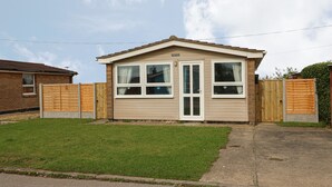 Une maison mobile de plain-pied avec une porte d’entrée, deux fenêtres et un petit porche.