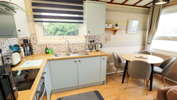 Une cuisine compacte avec une fenêtre, un coin repas avec des chaises et une petite table.