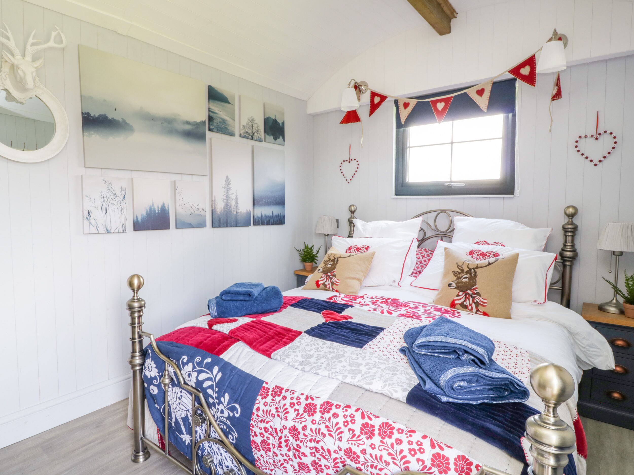 Ein Schlafzimmer mit Bett, Fenster und Wanddekorationen.