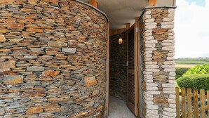 Eine Steinmauer mit einer Holztür und einem Holzzaun.