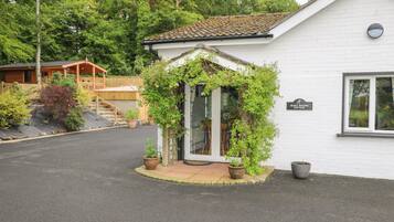 Un edificio blanco con techo de tejas y un letrero que dice "Quilt Waters Cottage".