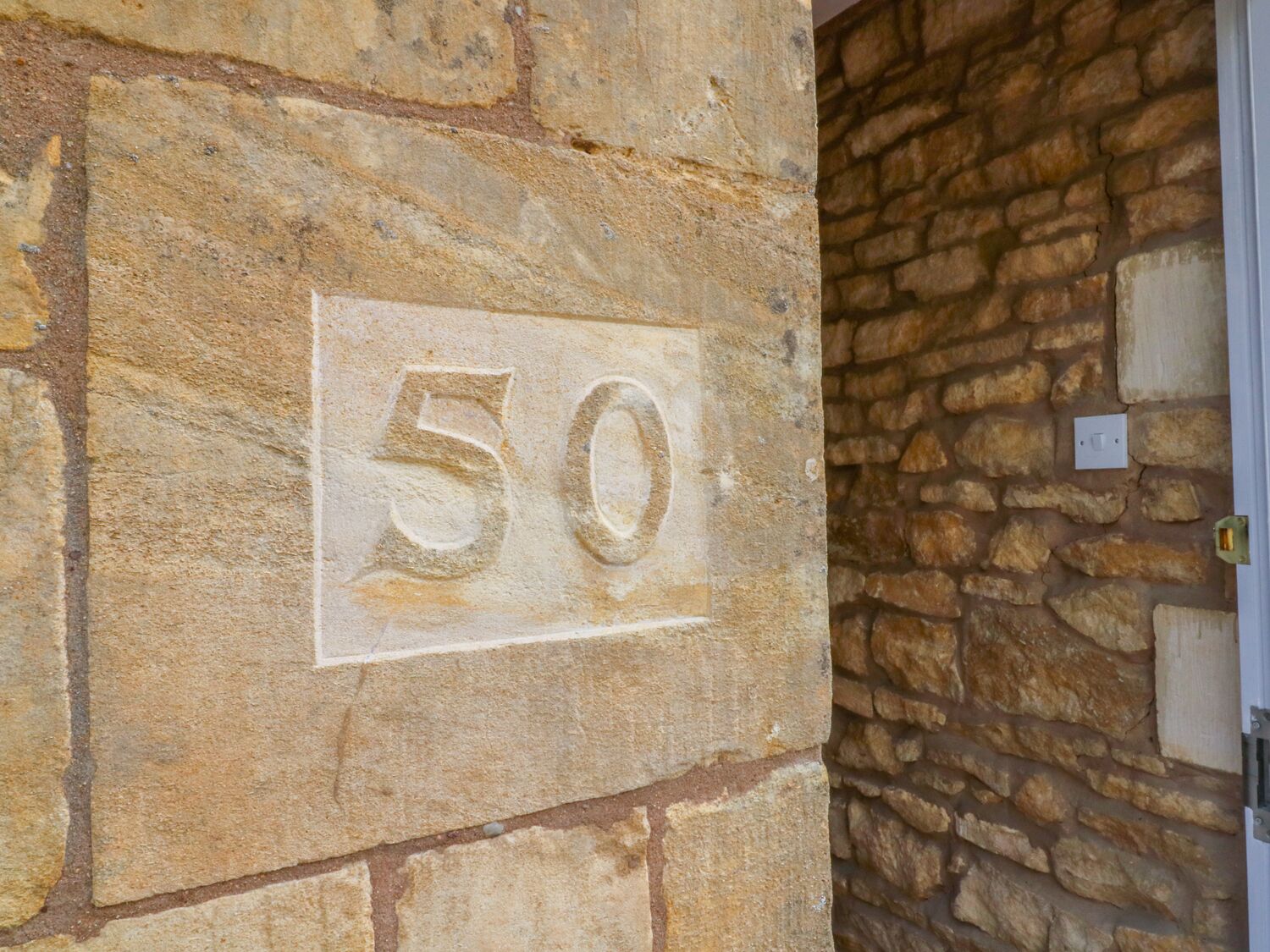 A stone wall with a number '50' carved into it.