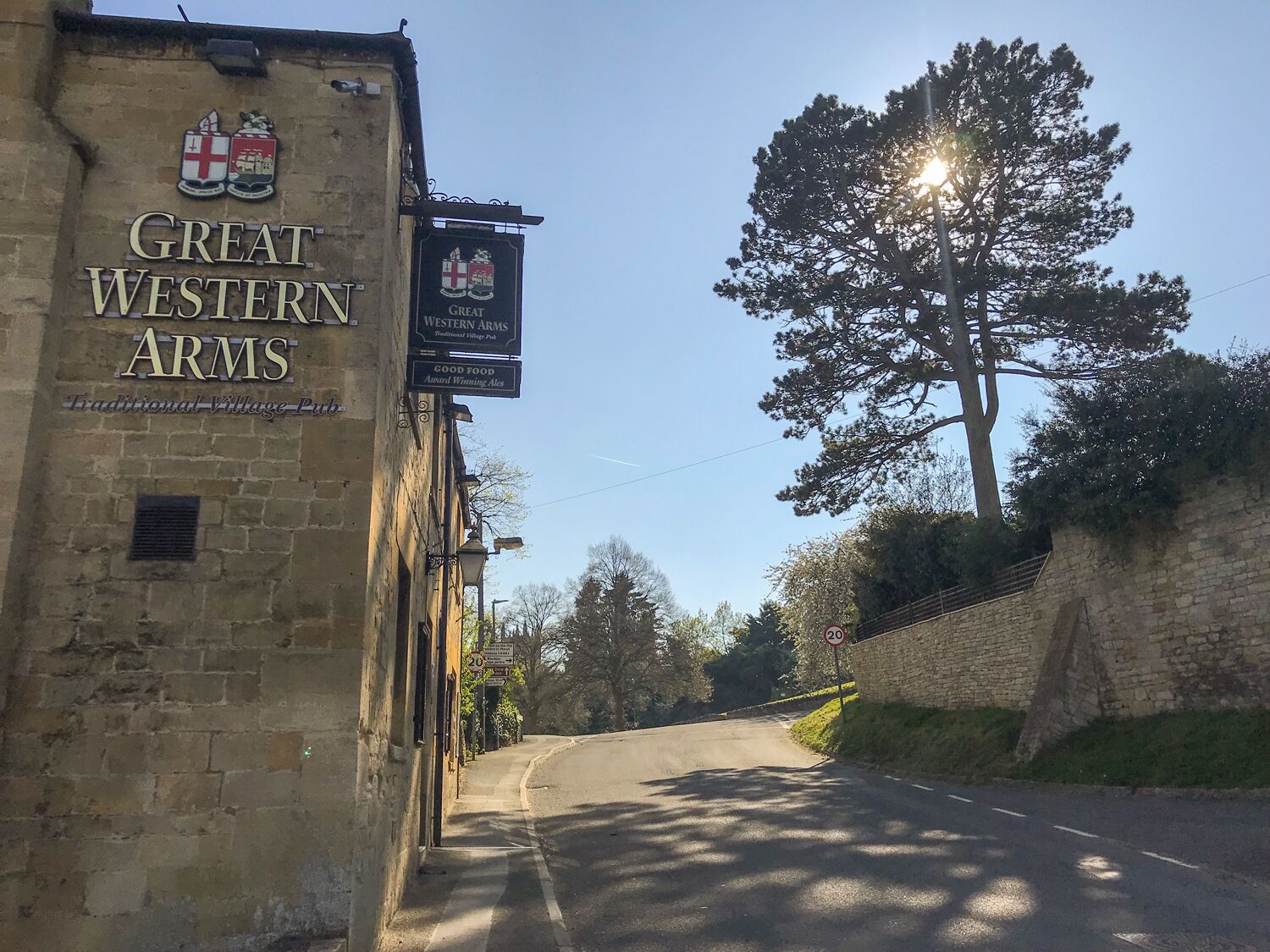 A traditional village pub named Great Western Arms with a stone facade and signage indicating it offers food and ales.