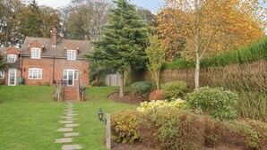 A brick house with a garden pathway leading to the entrance. - Knights Cottage (Maidstone)