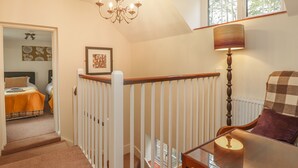 A bedroom with a bed, a nightstand, a dresser, and a window. - Knights Cottage (Maidstone)