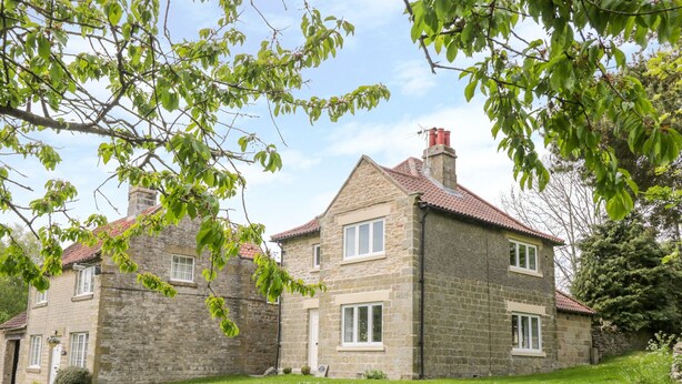 A stone house with a red-tiled roof, two visible windows, and a chimney. - Manor Cottage (Pickering)
