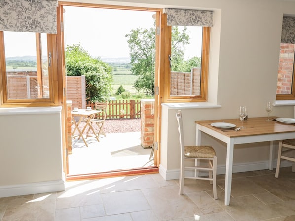 A bright kitchen with a view of a garden and countryside.