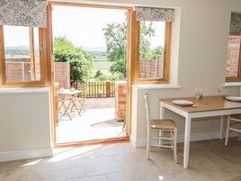 A bright kitchen with a view of a garden and countryside.