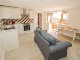 A compact kitchen with a built-in oven and a dining area with a table and chairs.
