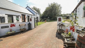 A quaint village street with a white building labeled "CHURCH VIEW" and a signboard with a red dragon emblem. - Primose Cottage (Milford Haven)