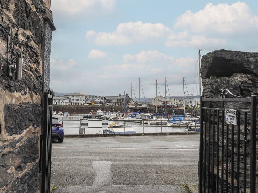 A marina with boats docked, a stone building on the left, and a 'No Parking' sign on the right.