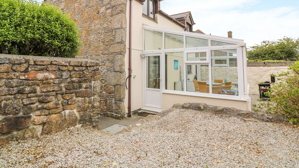 A stone house with a large glass windowed room. - Mossley Cottage (Penzance)
