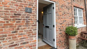 A brick building with a door labeled "3 Bella's". - Bella's Cottage (Driffield)