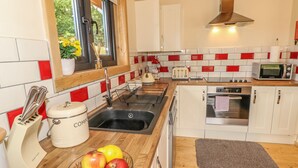 A compact kitchen with a sink, toaster, microwave, and oven. - Chale Farm Lodge (Ventnor)