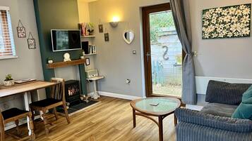 Una sala de estar acogedora con chimenea, televisor y una zona de estar cómoda.