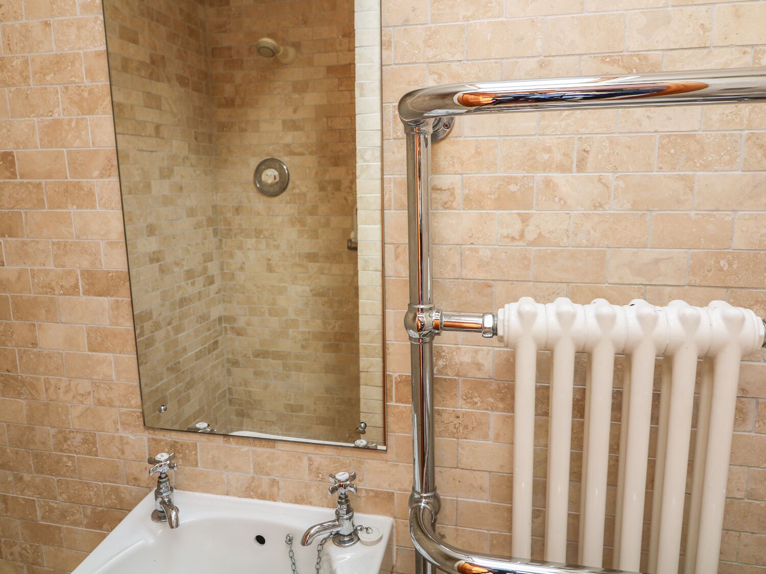 A bathroom with a white sink, a mirror, and a shower.