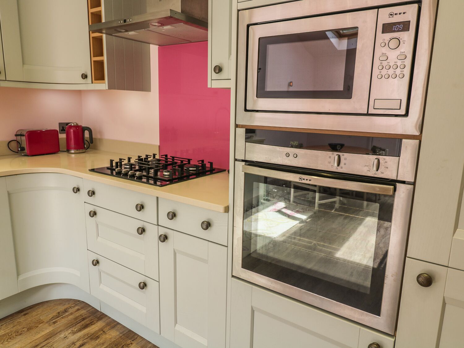 A compact kitchen with a microwave, oven, and gas stove.