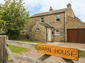 A stone house with a wooden fence and a sign that reads "Barn House." - Barn House (Leyburn)