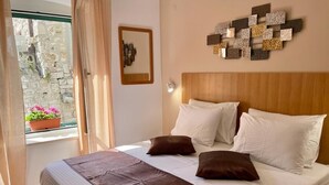 A neatly made bed with white and brown bedding, a wooden headboard, and a decorative wall piece.