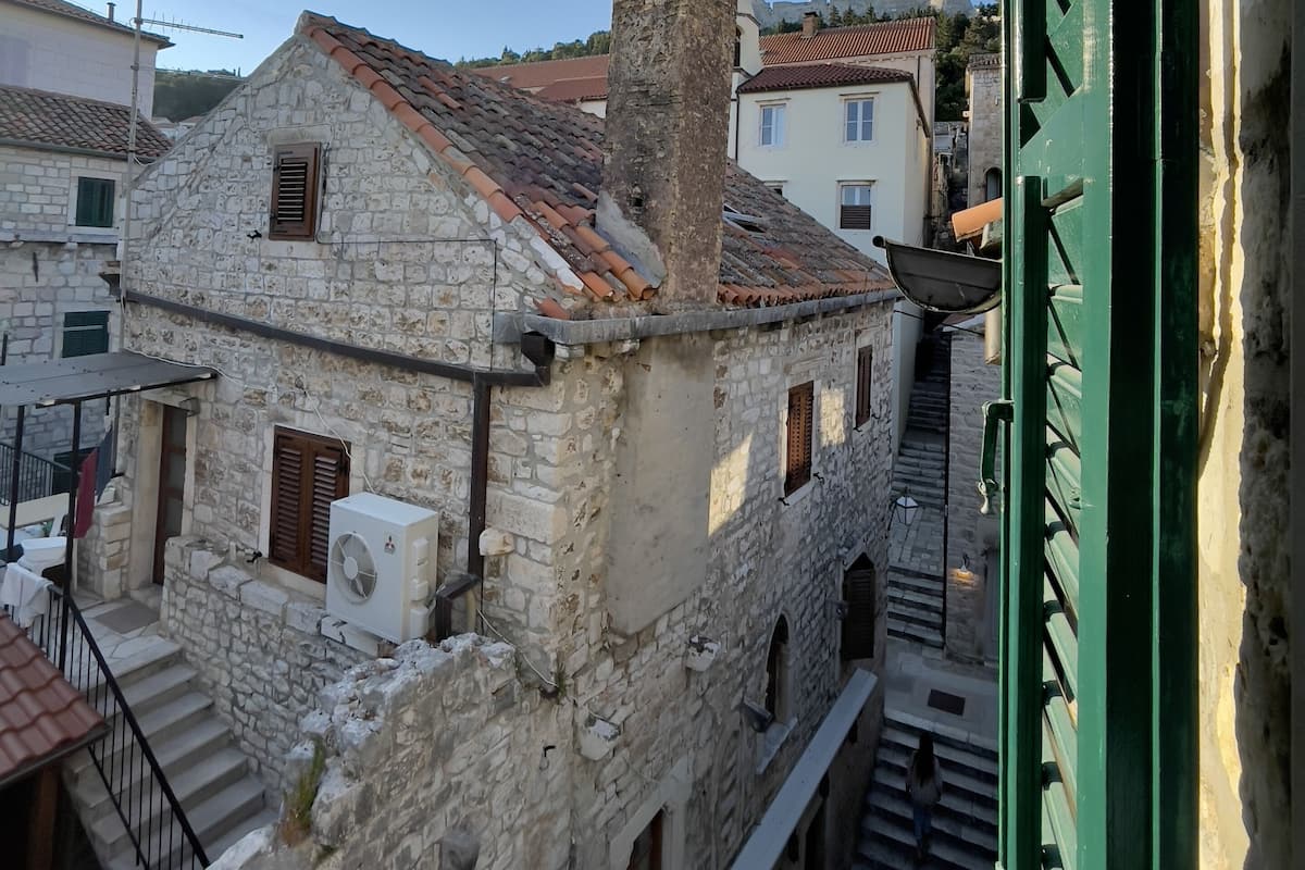 Um edifício de pedra com uma torre, uma escadaria e uma porta verde.