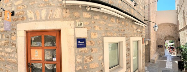 Un edificio de piedra con una puerta de madera que dice 
