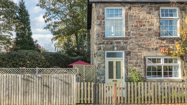 A stone building with a green door and two windows. - Wordsworth Cottage West (Morpeth)