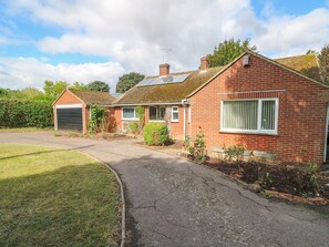 A two-story brick house with a garage, a small garden, and a paved driveway. - Glynde (Dover)