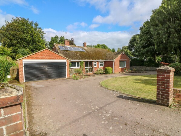 A two-story brick house with a garage, solar panels, and a well-maintained lawn. - Glynde (Dover)