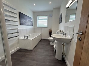 Une salle de bain moderne avec une baignoire, des toilettes et un lavabo.
