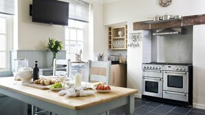 A modern kitchen with a wooden countertop, stainless steel appliances, and a built-in oven. - Albany House, Whitby (Whitby)