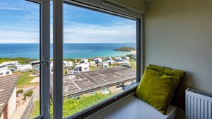 Ein Zimmer mit großem Fenster und Blick auf einen Caravanpark und das Meer.