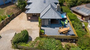 Ein Wohnhaus mit großer Terrasse, Schwimmbad und einer Stein-Terrasse.