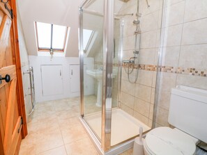 Une salle de bain moderne avec une douche à parois de verre, des toilettes blanches et un lavabo.