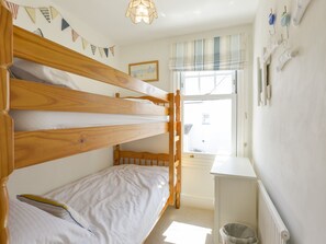 A bunk bed room with a window, a radiator, and a wall-mounted trash bin. - Beachcomber (Padstow)