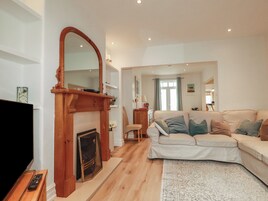 Una sala de estar con chimenea, sofá y televisor.