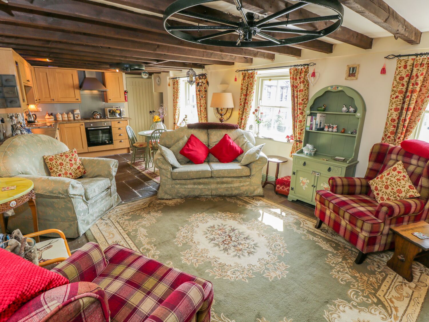 A cozy living room with a sofa, armchairs, and a green cabinet.