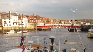 Un porto con barche ormeggiate, un ponte e edifici sullo sfondo.