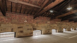 Un'ampia sala con soffitto in legno e pareti in mattoni.