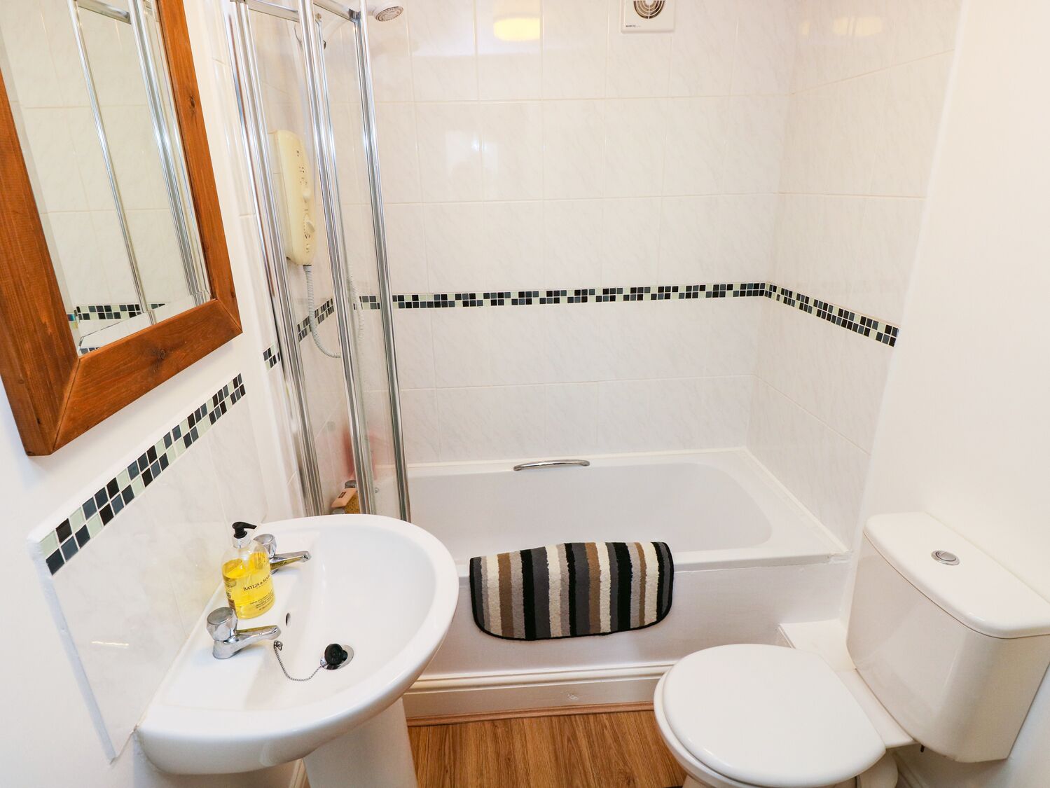 A bathroom with a shower, toilet, and sink.